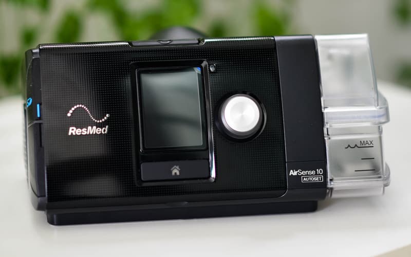 Aparelho de CPAP da ResMed sobre uma mesa clara
