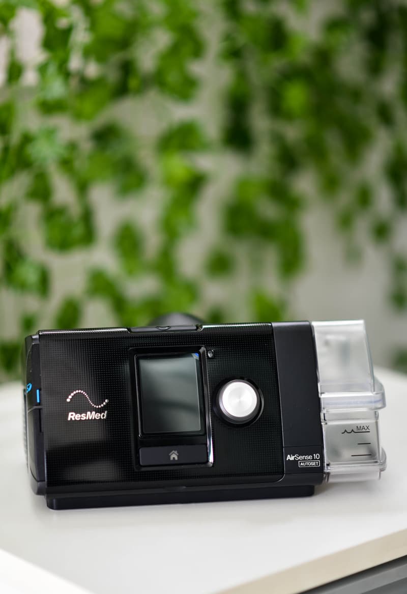 Aparelho de CPAP da ResMed sobre uma mesa clara