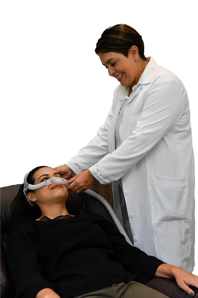 Fisioterapeuta da Sonofisio ajustando a máscara de CPAP em uma paciente