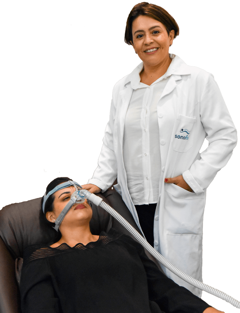 Fisioterapeuta da Sonofisio ao lado de uma paciente que usa máscara de CPAP